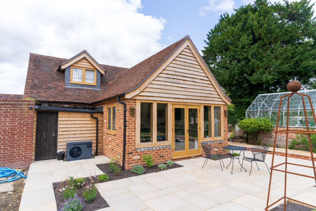 Naylands: bespoke barn conversion featuring an on-site oak gable, Bolney Stoves wood burner, Benchmarx kitchen, high-grade timber, full M&E works and refined finishes.